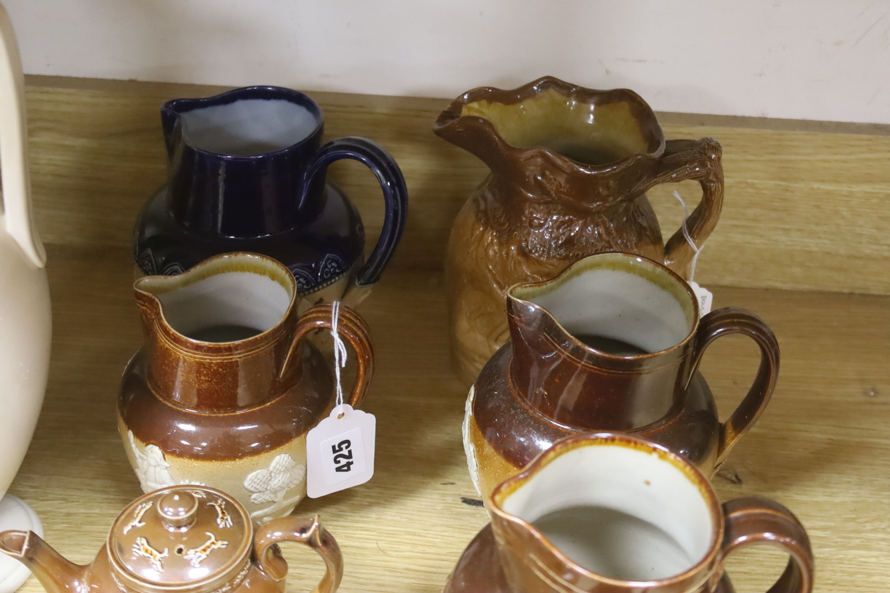 A group of Doulton stoneware: jugs, a teapot, butter dish and a pipe salesman's model